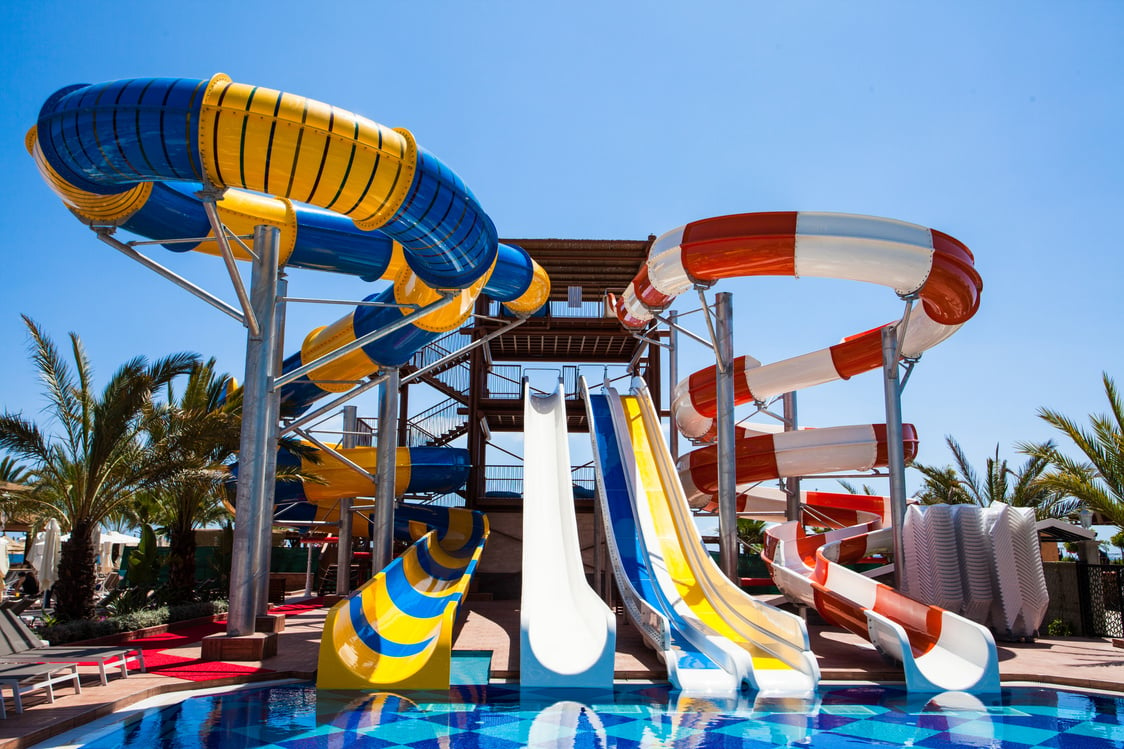 Colorful waterpark tubes and pool in tropical aquapark